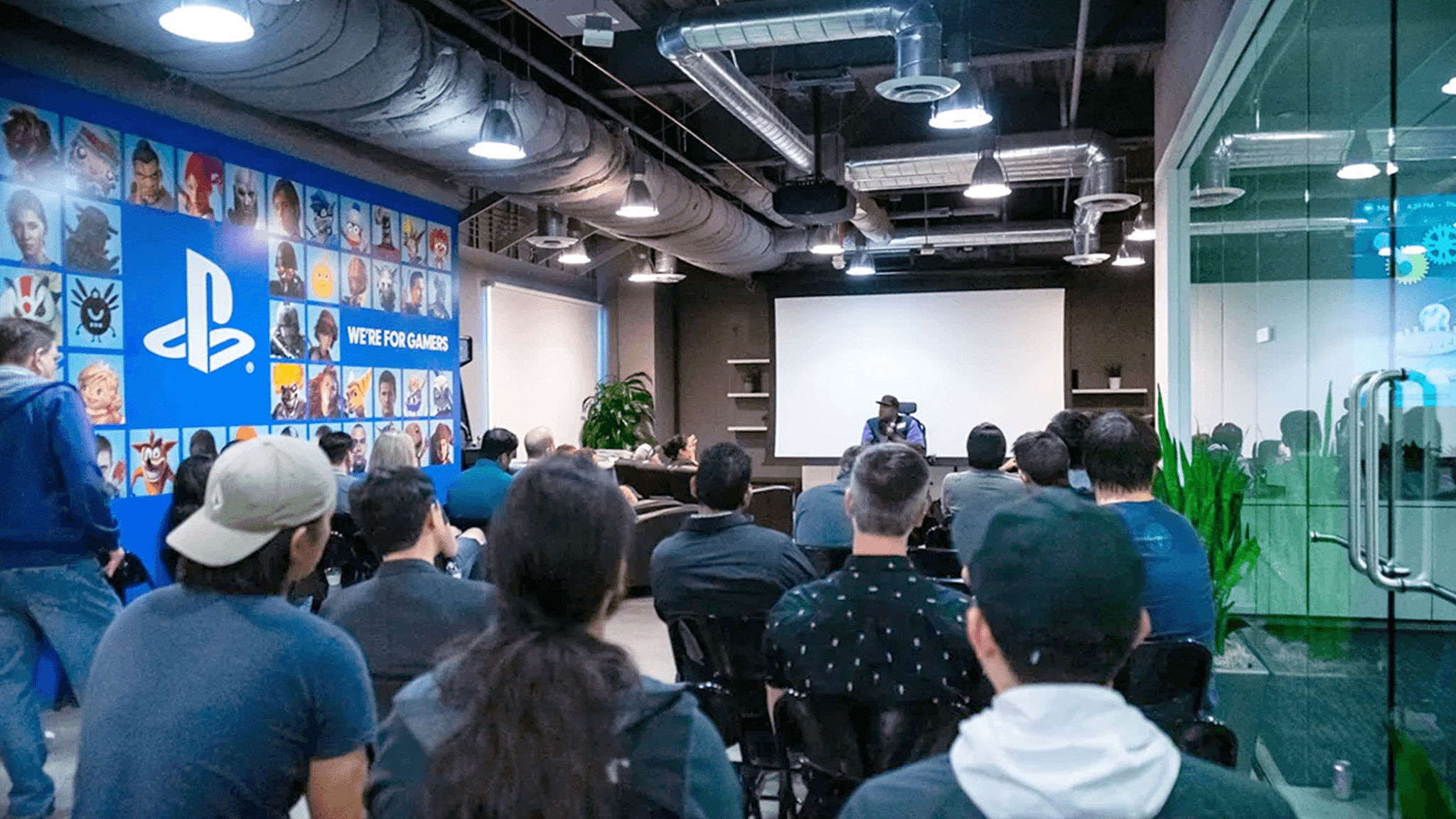 Sony Interactive employees listening to a talk in a company meeting room.