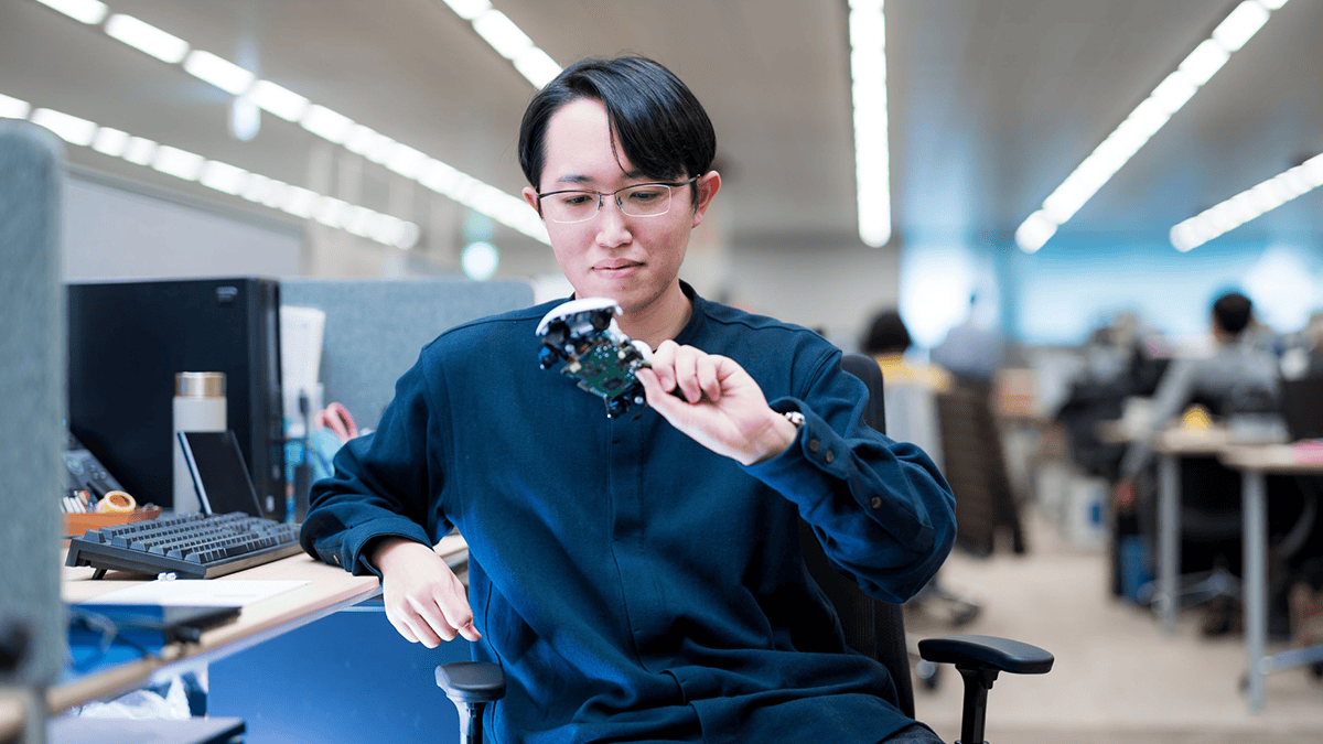 技術者が解体されたDualSenseコントローラーを手に持っている